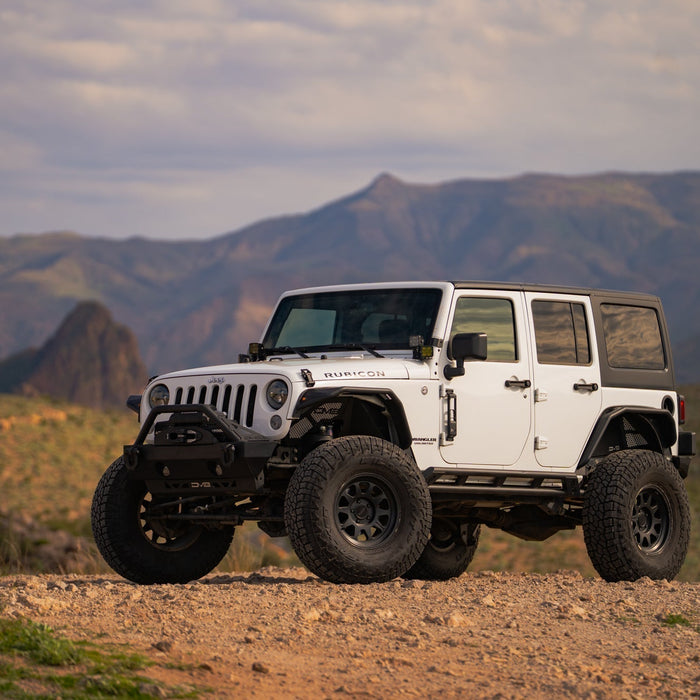 A Jeep JK off-road in the desert with DV8 bumpers.