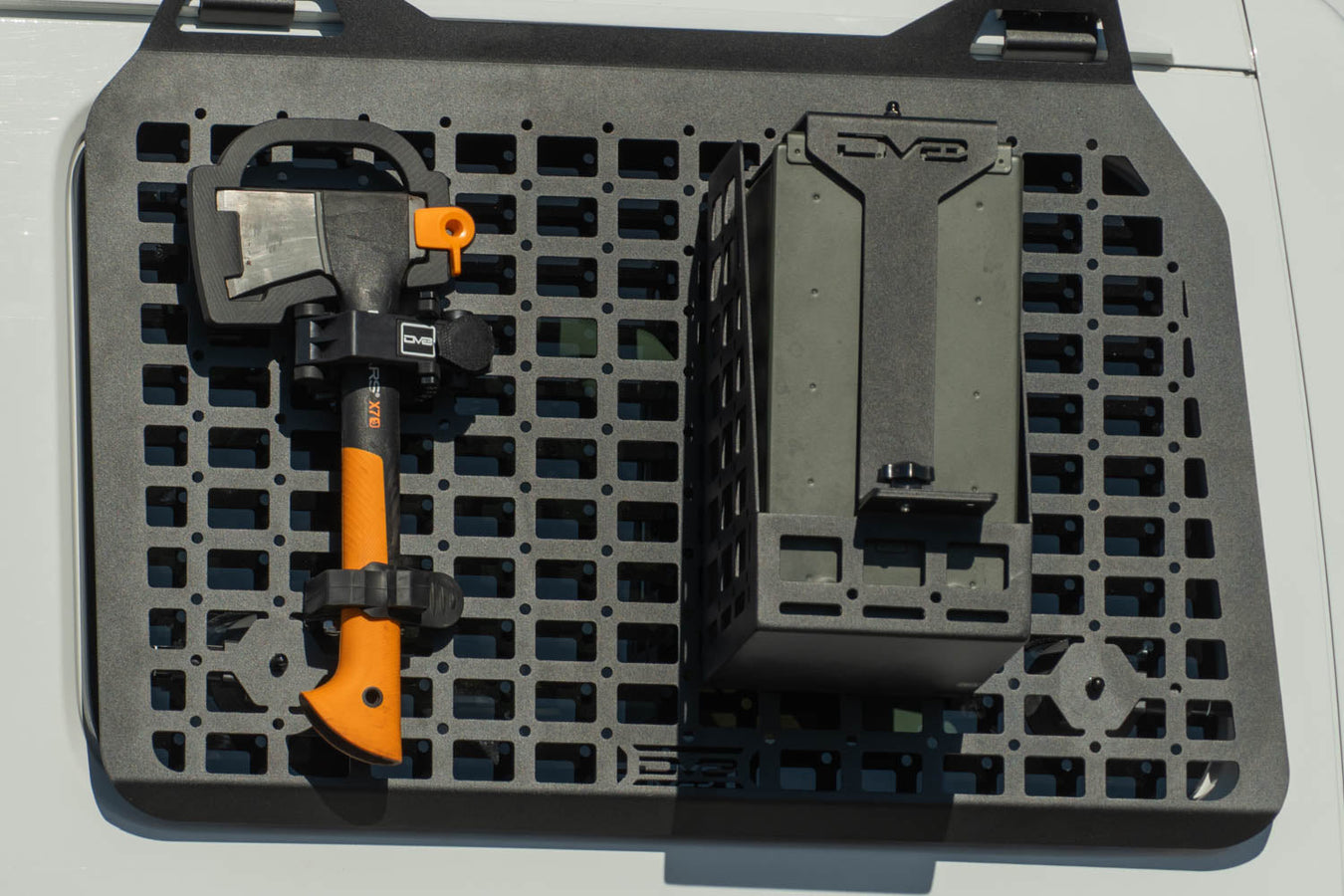 Installed Universal Locking Tool Clamp with axe next to ammo can carrier on Jeep molle panel by DV8 Offroad