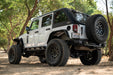 White 2007-2018 Jeep JK 4-Door with DV8 Fastback Hard Top parked on a dirt road surrounded by trees