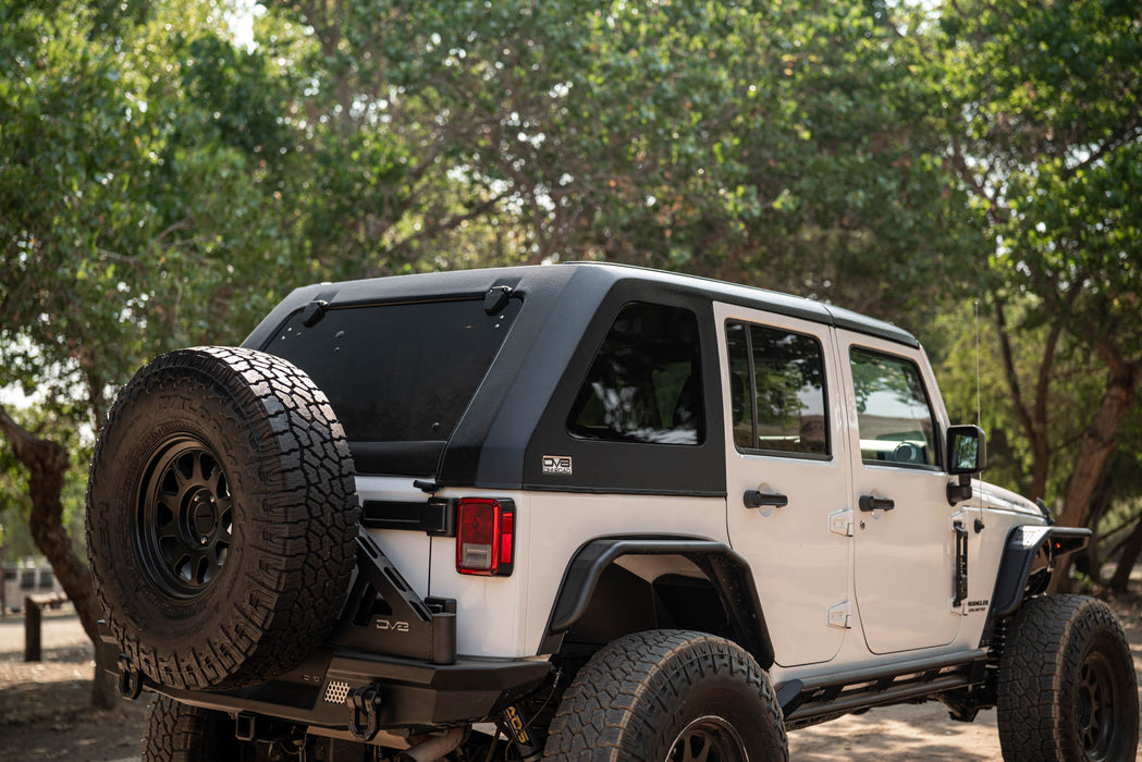 White 2007-2018 Jeep JK 4-Door with DV8 Fastback Hard Top and off road accessories tires in a forest setting