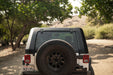 Back view of a 2007-2018 Jeep JK 4-Door with DV8 Fastback Hard Top on a dirt road with trees in the background