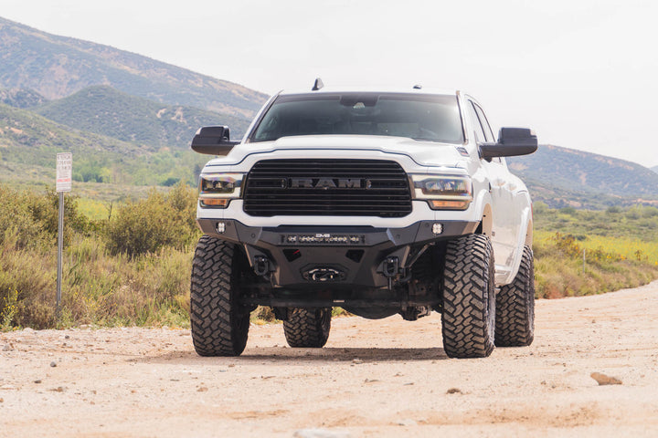 Spec Series Front Bumper for the 2019-2026 Ram 2500/3500 on a dirt road with mountains in the background