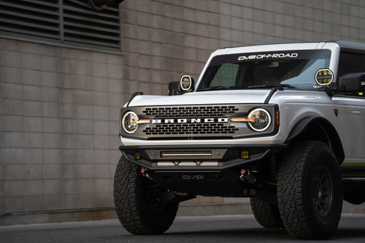 White Ford Bronco off-road vehicle parked in front of a brick wall.