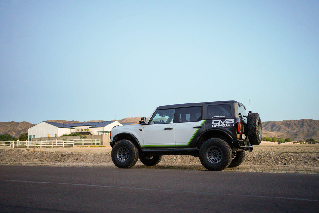 Ford Bronco with off road parts on a road with mountains in the background
