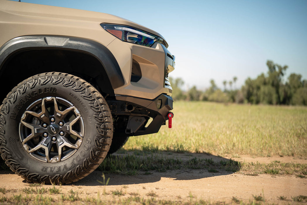Beige off-road Chevy Colorado ZR2 with Spec Series Front Bumper on a dirt road with a natural landscape in the background