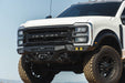 White Ford Super Duty Roush truck with large off-road tires against a clear blue sky. It has our Ford F-250/350 Spec Series Front Bumper