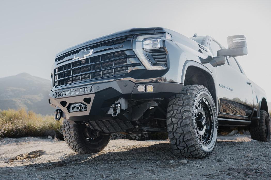 2024-2026 Chevy Silverado 2500/3500  with our Spec Series Front Bumper on a dirt road with mountains in the background