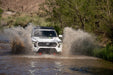 Spec Series Front Bumper on the 4th Gen Toyota Tacoma driving through a water crossing in a natural setting