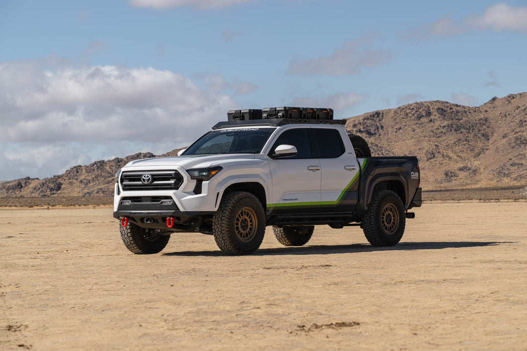 Toyota truck in a desert landscape with mountains in the background, fully equipped with off road parts.