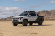 Toyota truck in a desert landscape with mountains in the background, fully equipped with off road parts.