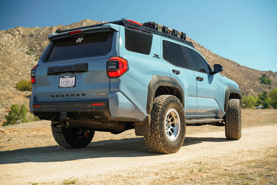 Blue 4Runner with off-road tires and Spec Series Roof Rack on a dirt road with mountains in the background