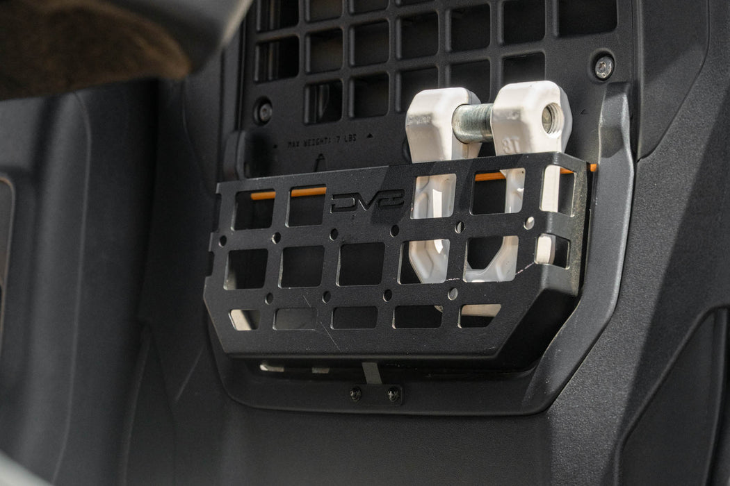 Seat-back molle pocket on the bronco with a DV8 D-Ring being held for scale.