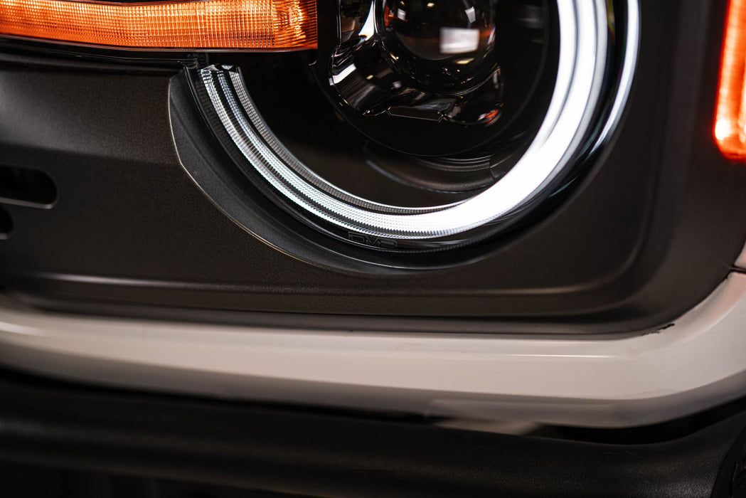 Close-up of a car headlight with a visible brand logo.