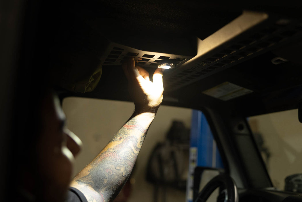 Man turning off the Elite White Push Button Dome Light 