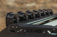 Rear-angle view of Baja Designs Linkable Lightbar Mount for DV8 Roof Rack Light Option installed on DV8 Toyota roof rack