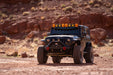Jeep Wrangler JK in a desert landscape with rocky background, DV8 Offroad bumpers and accessories.