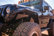Black off-road Jeep with large tires on a desert landscape. DV8 Off Road Parts.