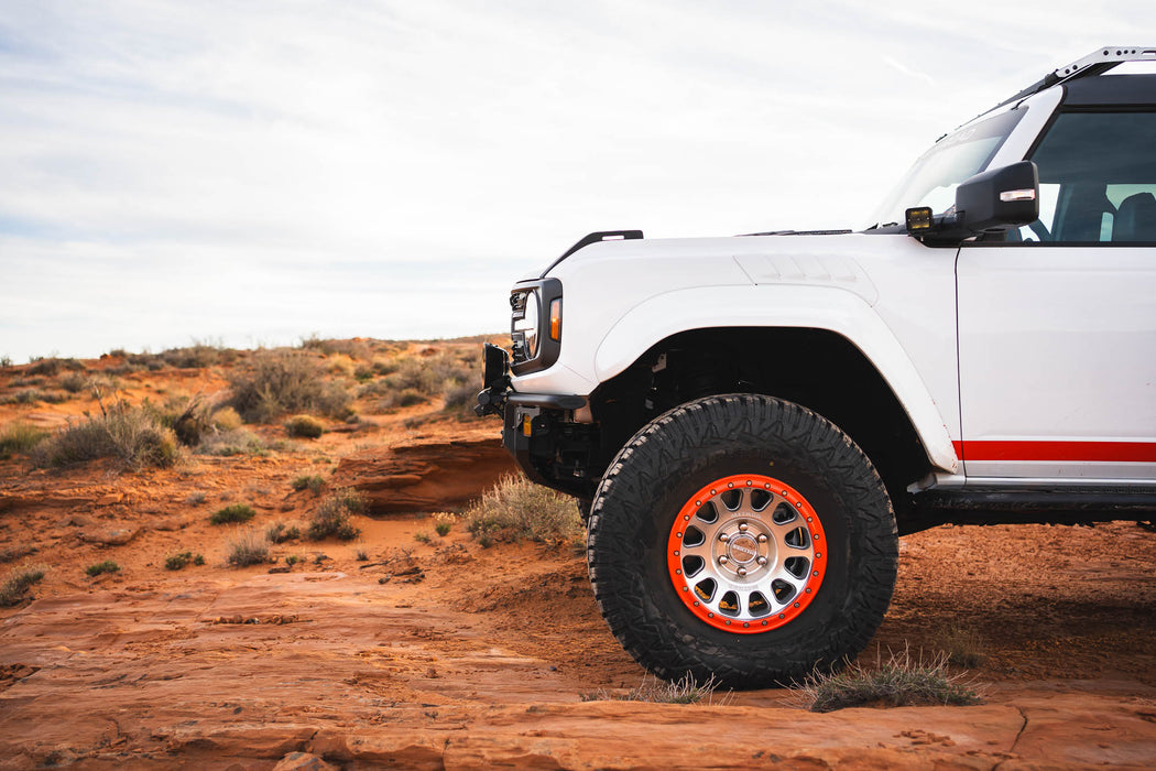 Side profile of White Ford Bronco Raptor with Tube Front Bumper with large tires on a desert landscape