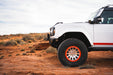 Side profile of White Ford Bronco Raptor with Tube Front Bumper with large tires on a desert landscape