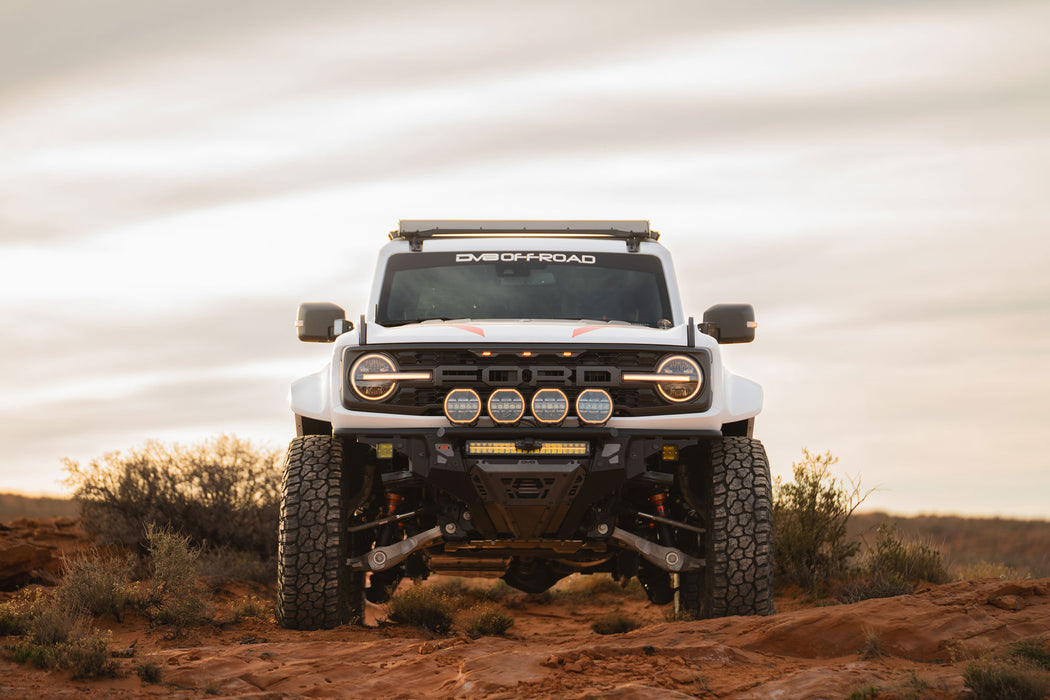 White Ford Bronco Raptor with Tube Front Bumper on a desert landscape.