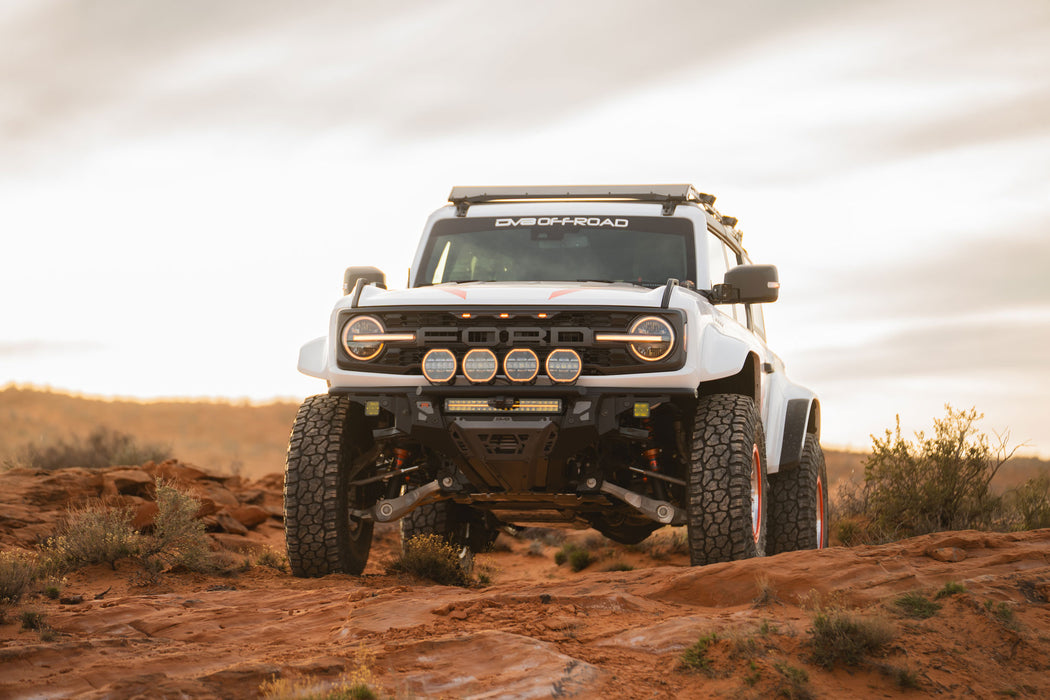 Off-road Ford Bronco Raptor with Tube Front Bumper on a rocky terrain with a cloudy sky