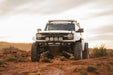 Off-road Ford Bronco Raptor with Tube Front Bumper on a rocky terrain with a cloudy sky