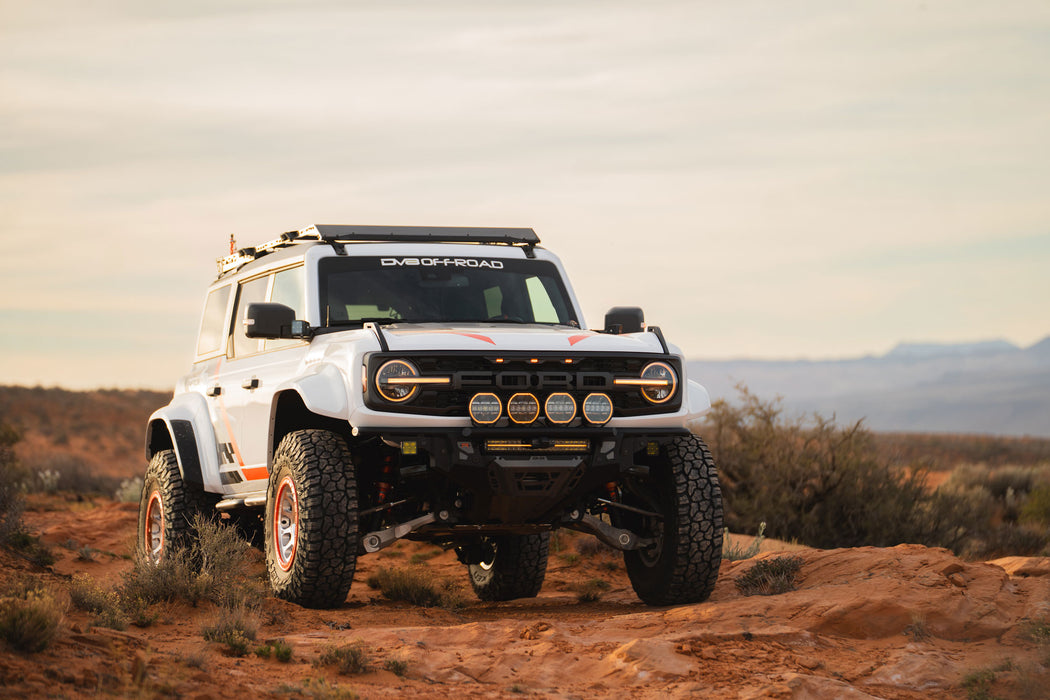 White Ford Bronco Raptor with Tube Front Bumper with large tires on a desert landscape