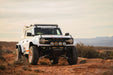 White Ford Bronco Raptor with Tube Front Bumper with large tires on a desert landscape