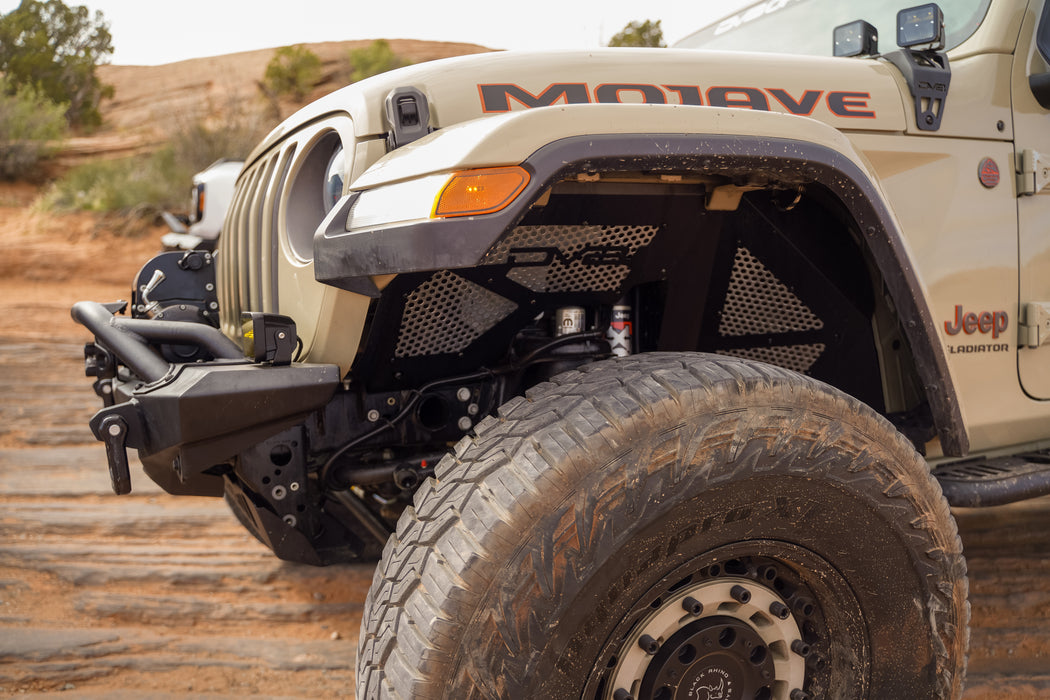 Close-up of a Jeep Gladiator with 'Mojave' branding on a desert road. It is equipped with off road bumpers and accessories.