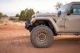 Jeep Gladiator Mojave on a dirt road with desert landscape in the background, off road bumpers and armor.
