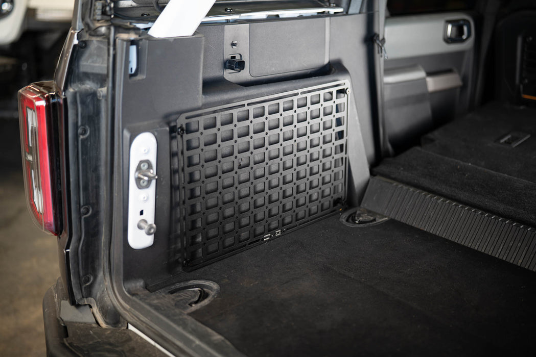 Trunk of a vehicle with a Universal Molle Panel installed on side wall.