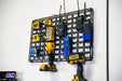 Wall-mounted Universal Molle Panel with various power tools and equipment on a white wall.