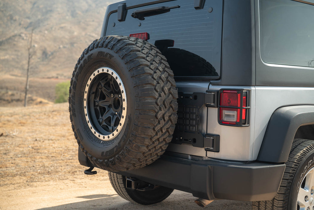 Full-sized spare tire with Jeep Wrangler JK Tailgate Reinforcement Molle Panel installed.