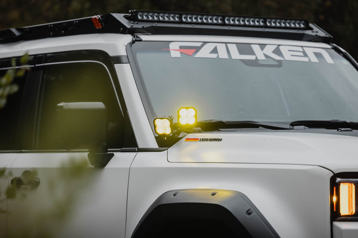 2024+ Toyota Land Cruiser Ditch Light Brackets installed with DV8 Elite Series Amber Lights turned on