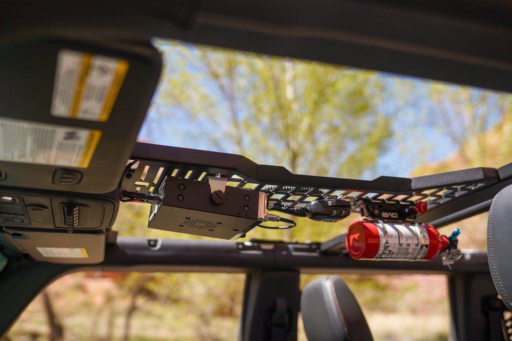 Radio and fire extinguisher mounted to overhead molle panel.