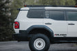 Land Cruiser with white wheels, falken tires, DV8 Side Steps, DV8 Spec Series Roof Rack, and DV8 2024+ Toyota Land Cruiser & Lexus GX 550 Exterior Window Molle Panel installed on the passenger side