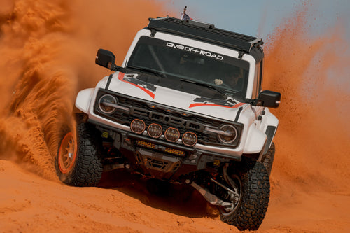 White Ford Bronco Raptor with Tube Front Bumper driving through sand
