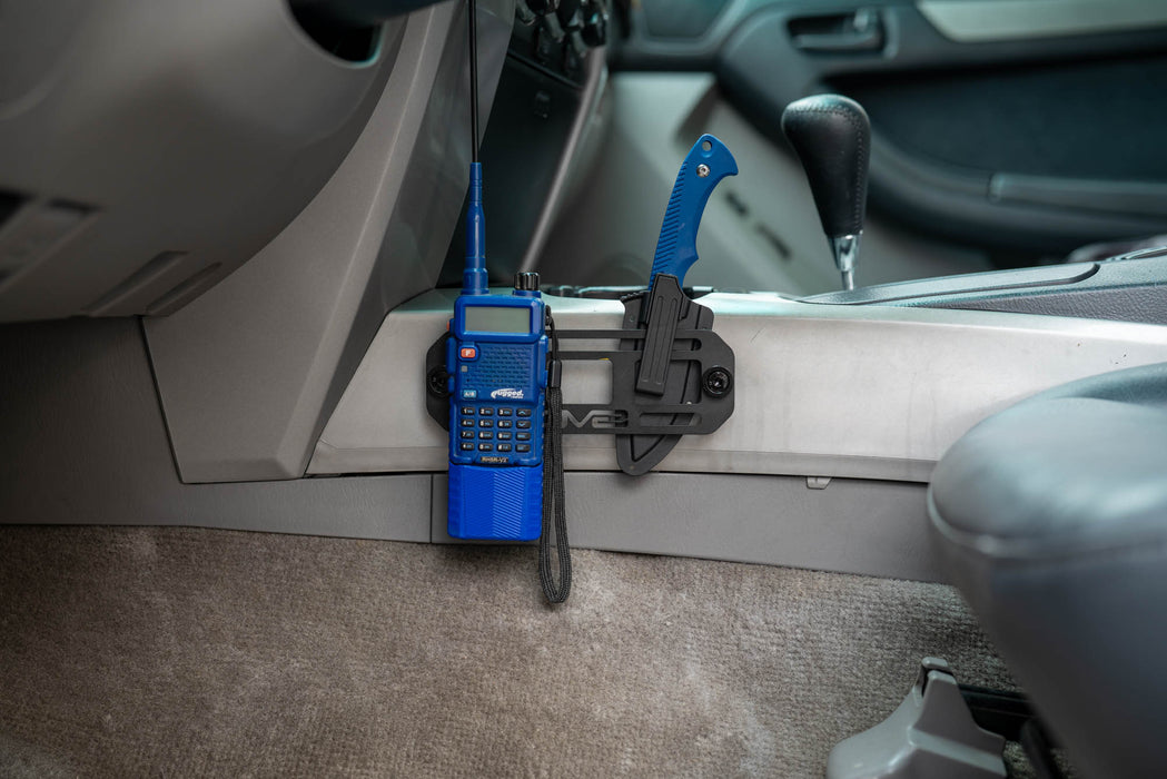 Blue walkie-talkie attached to a center console with the universal molle panel.