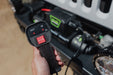 Person holding wired remote control on the DV8 Xtract 9.5k Synthetic Rope Winch, with 12 ft cable