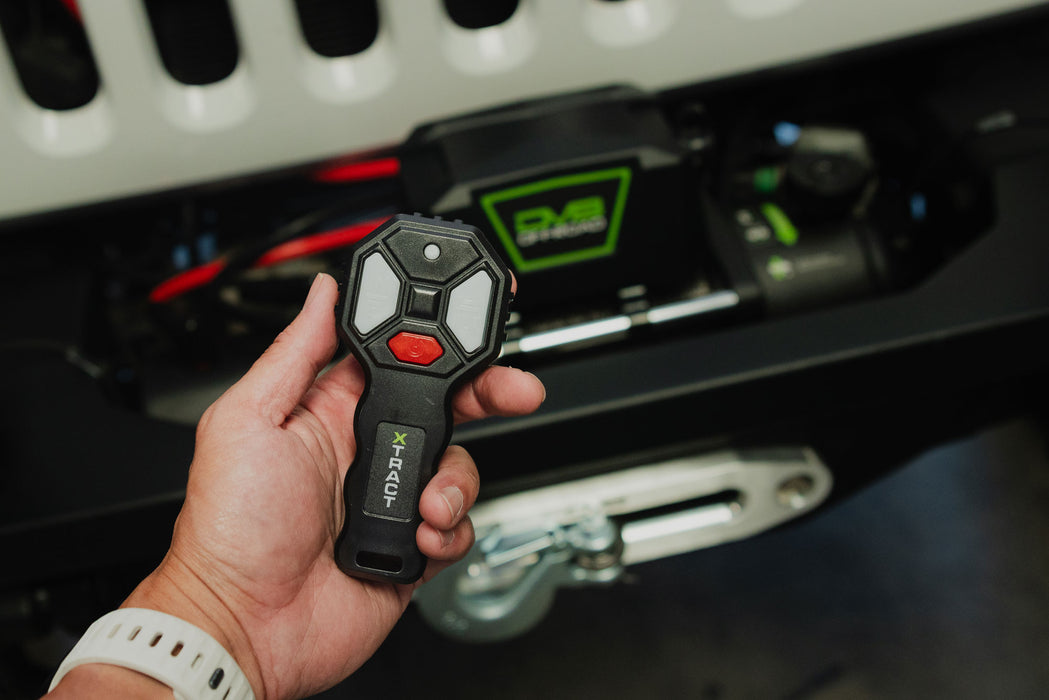 Person holding wireless remote with 150 foot range on the DV8 Xtract 9.5k Synthetic Rope Winch