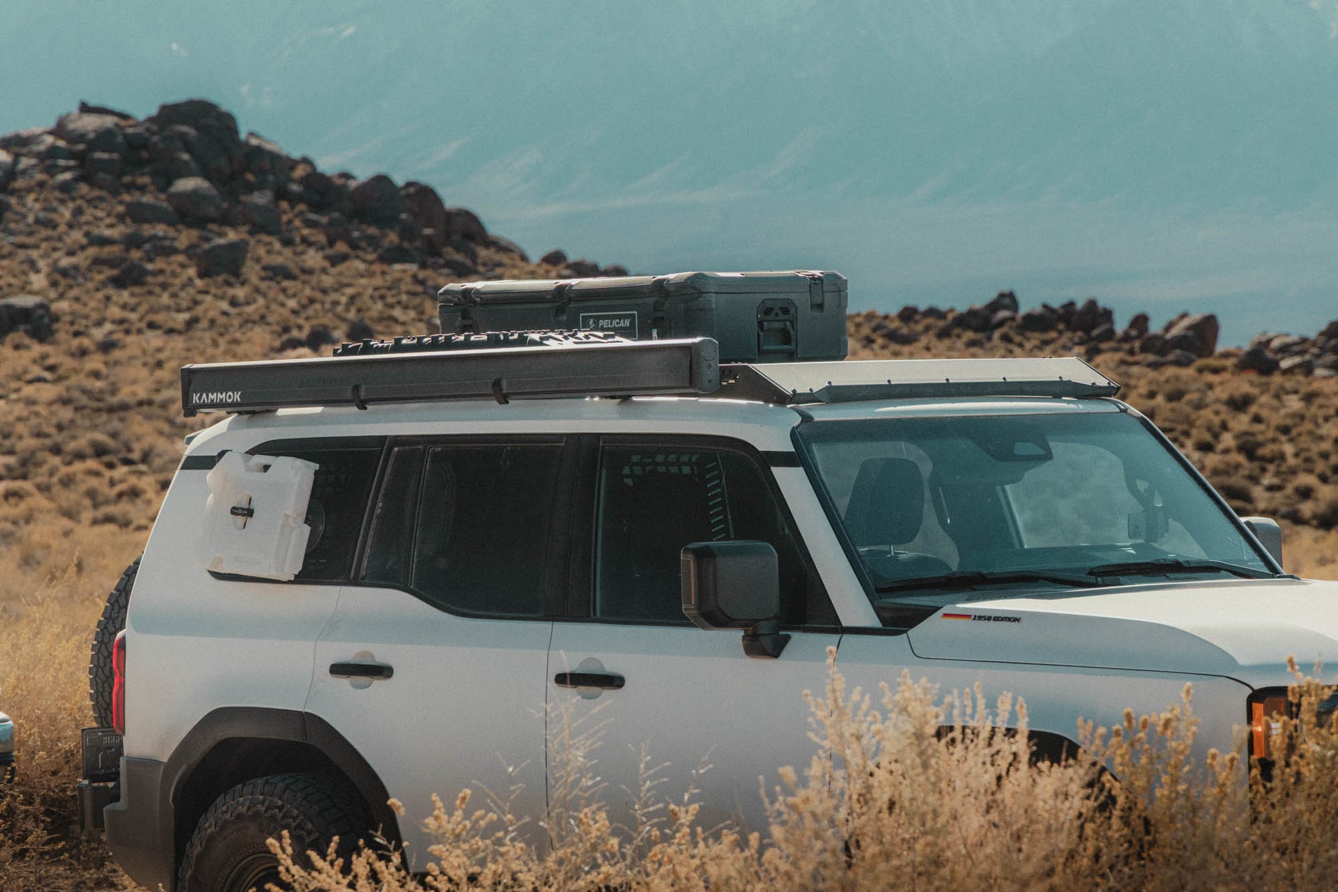 Land Cruiser SUV with roof rack in a desert landscape