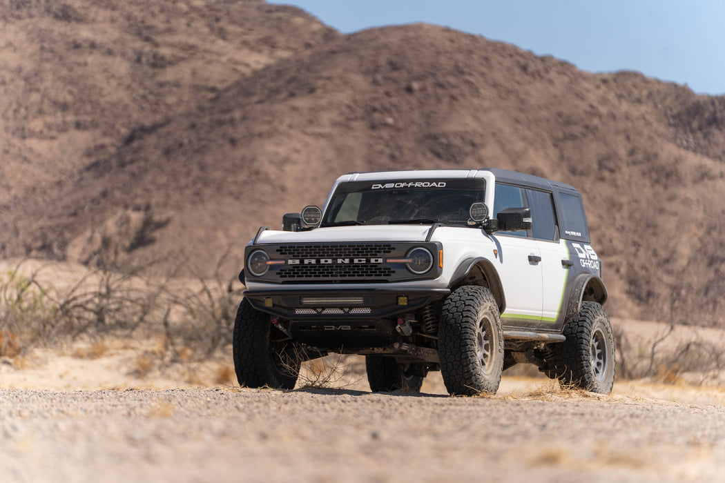 White Bronco with Competition Series front bumper in a bright, arid desert.