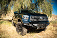 Zoomed out photo of the Tundra off-road front bumper mounted to the truck in a field.